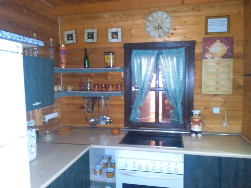 a kitchen with a stove and a clock on the wall at El mirador del consuelo in Jorquera