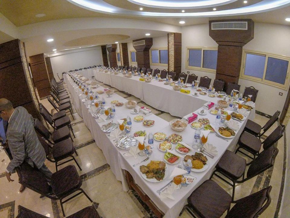 einen langen Tisch mit Teller mit Lebensmitteln drauf in der Unterkunft St. Marie House in Asyut