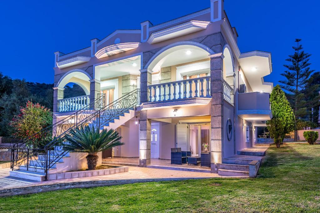 a large white house with a large balcony at Erato Apartment in Tsilivi