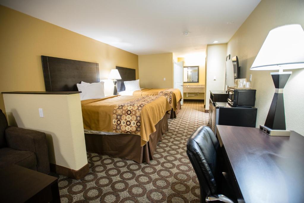 um quarto de hotel com duas camas e uma televisão em Relax Inn and Suites Kuttawa em Kuttawa
