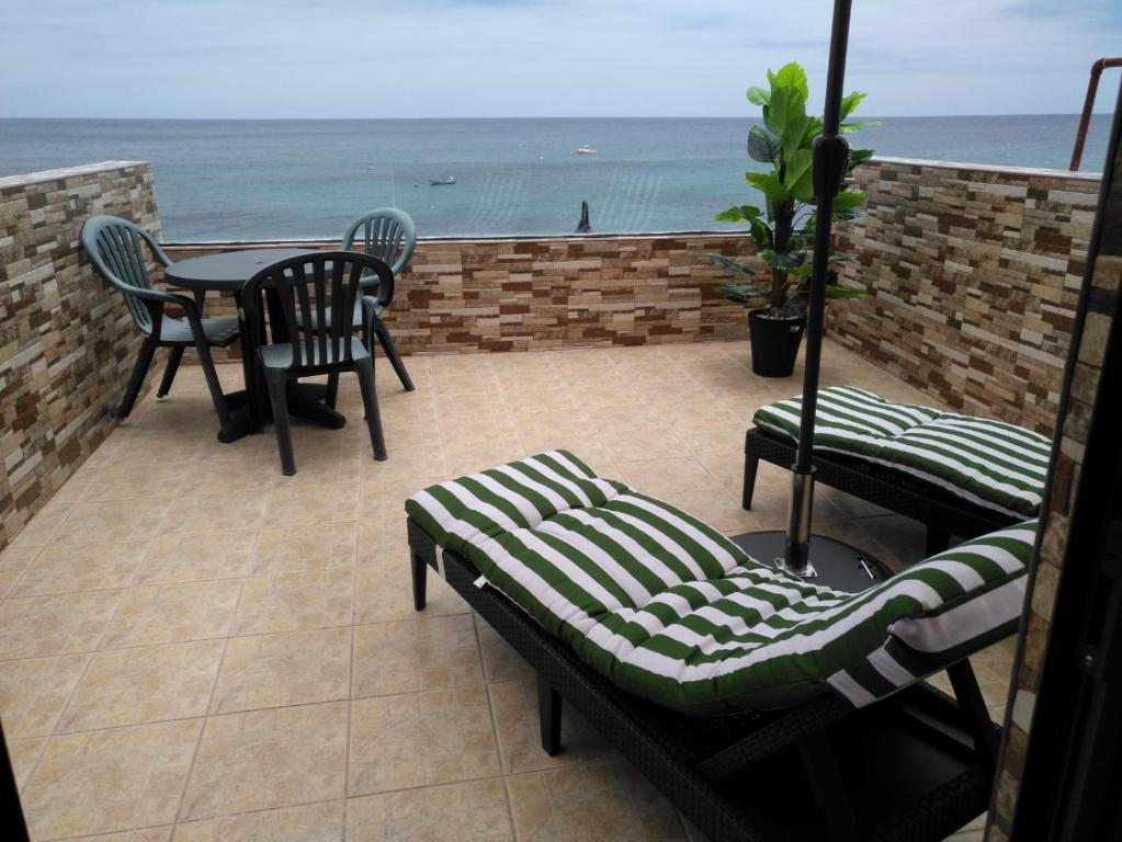 a patio with a table and chairs and the ocean at Casa Corina. Primera línea de mar in Punta de Mujeres