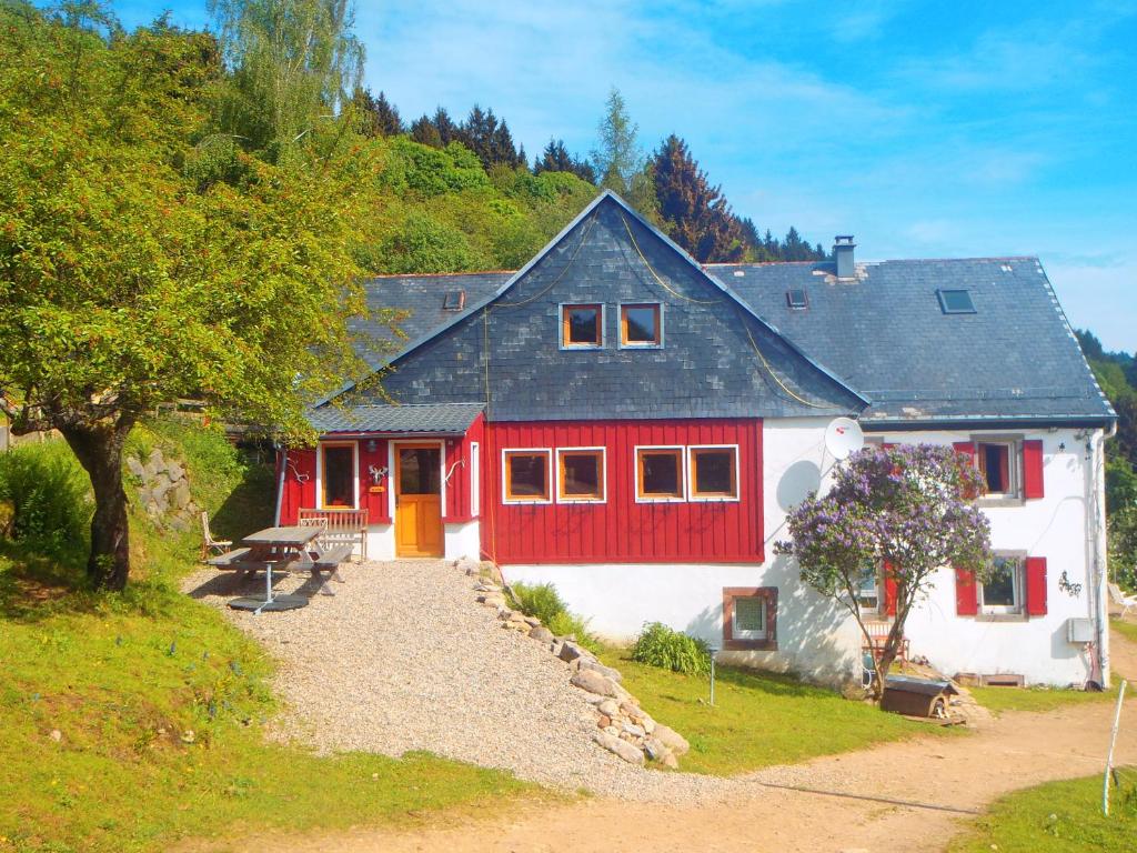 a red and white house with a red door at La Petite Finlande in Orbey