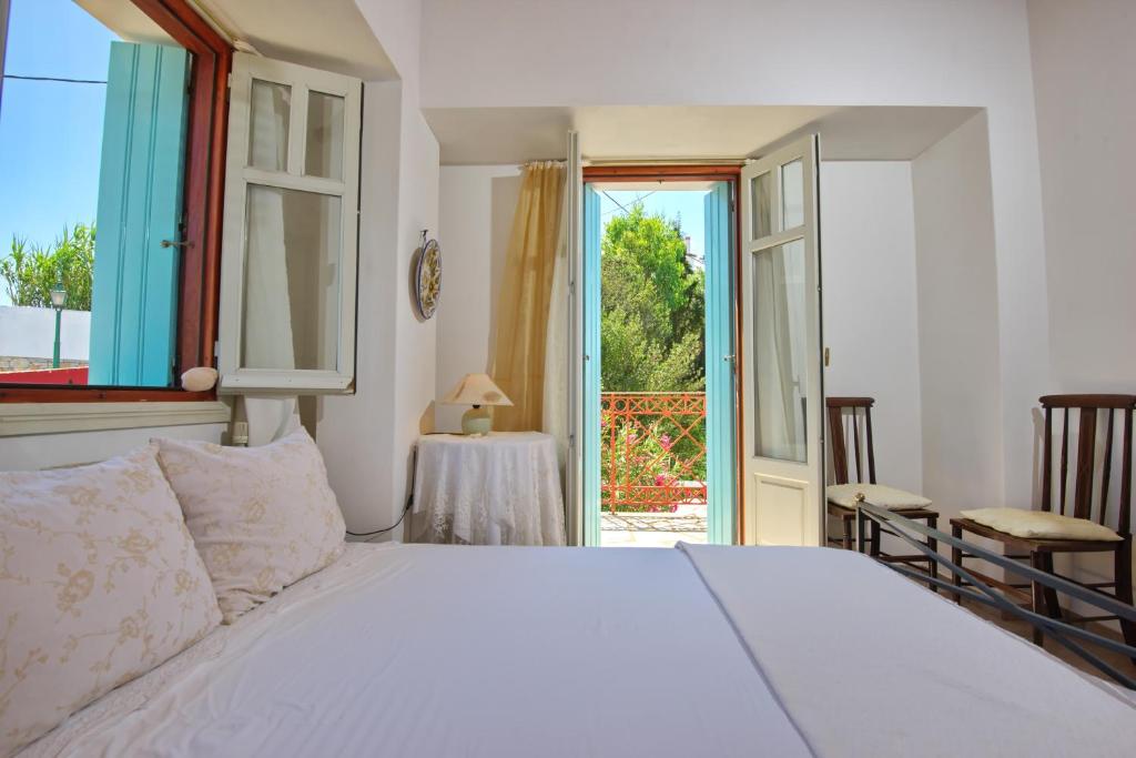 a bedroom with a white bed and an open door at Villa Frederike in Alonissos Old Town in Alonnisos