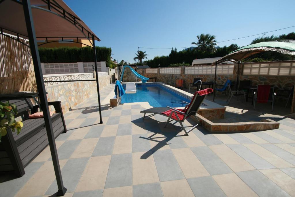 una piscina con una silla y un tobogán en Villa Brownies, en Els Poblets