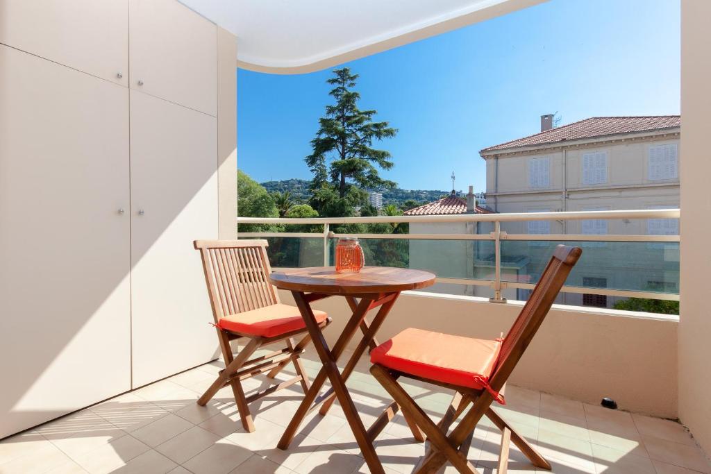 einen Tisch und zwei Stühle auf einem Balkon mit Aussicht in der Unterkunft Cannes Centre ville in Cannes