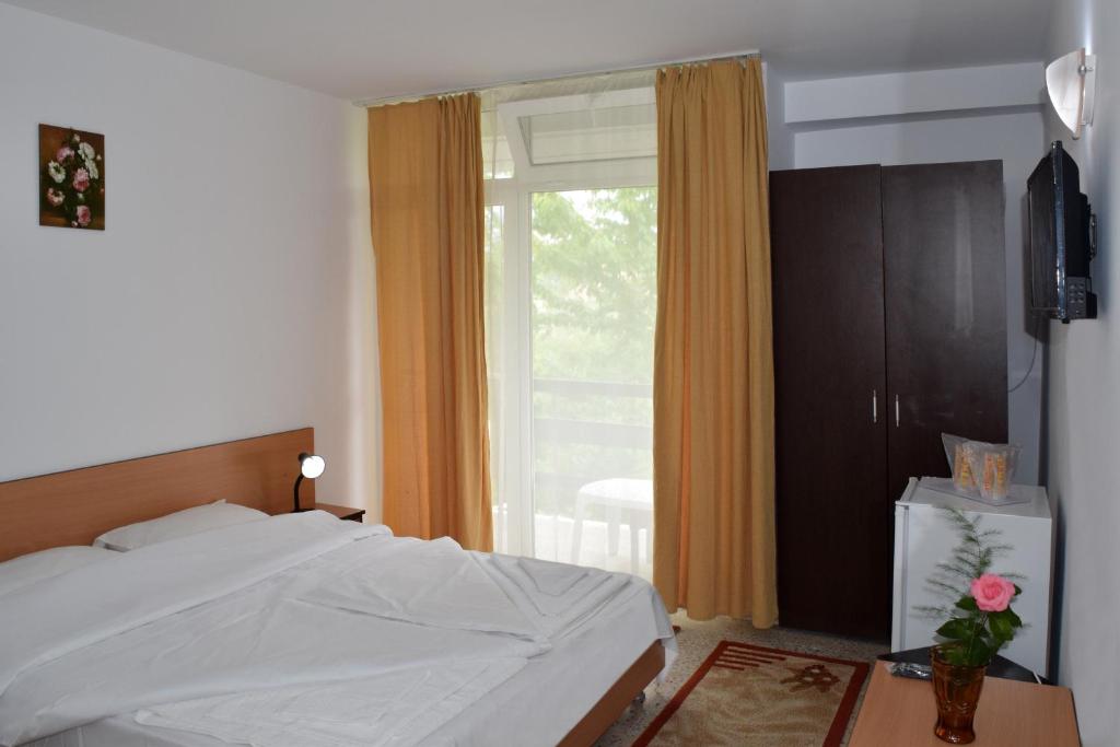 a bedroom with a white bed and a window at Hotel Sanda in Venus