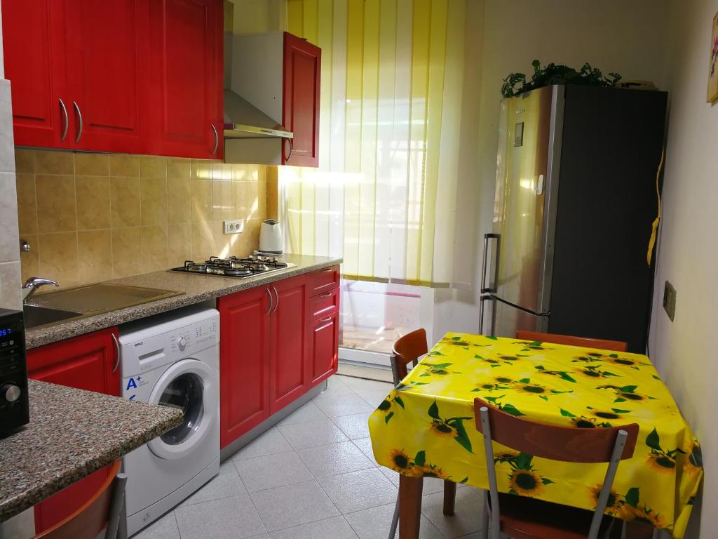 アルゲーロにあるMiraの赤いキャビネットとテーブル(黄色いテーブルクロス付)が備わるキッチン