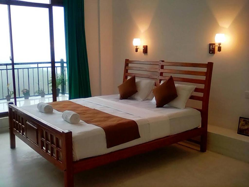 a bedroom with a large wooden bed in a room with windows at HIDE IN HANTANA The best place to hide in Kandy in Kandy