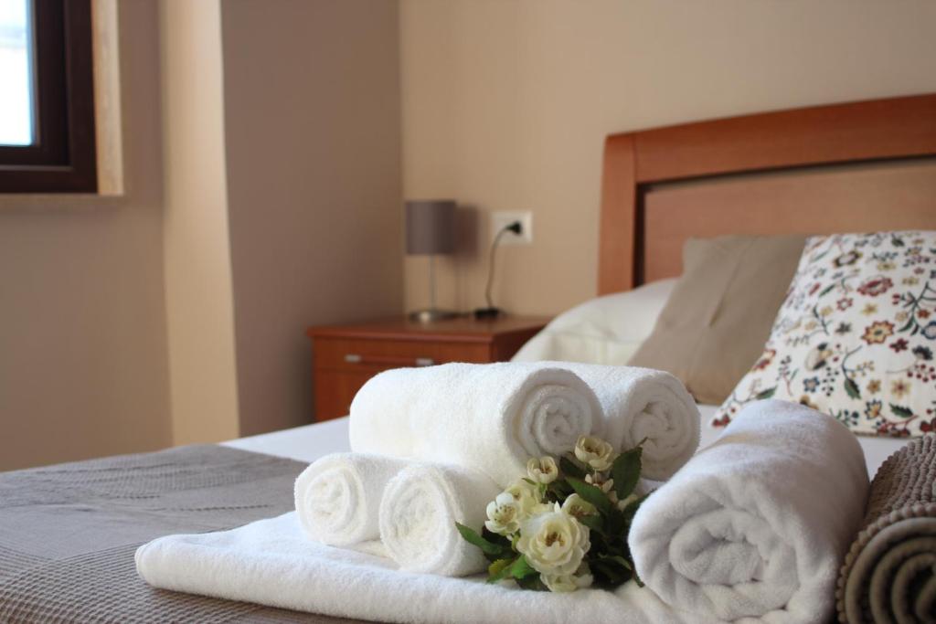 a bedroom with towels and flowers on a bed at Conte Spada Home in Nardò