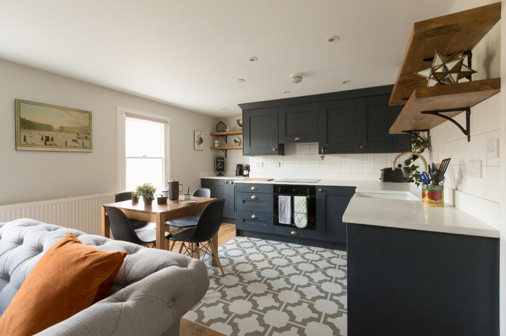 a kitchen with a couch and a table in a room at Osric Apartment in Bath