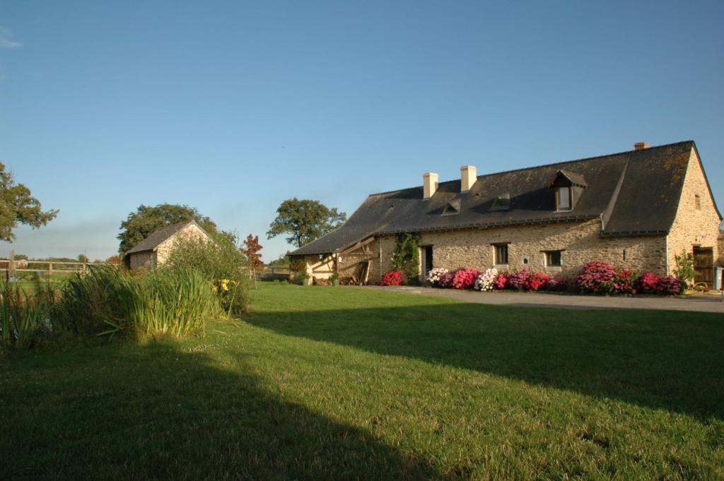 une maison avec une grande cour avec une pelouse dans l'établissement Grand Mainguet, à Saint-Lambert-la-Potherie