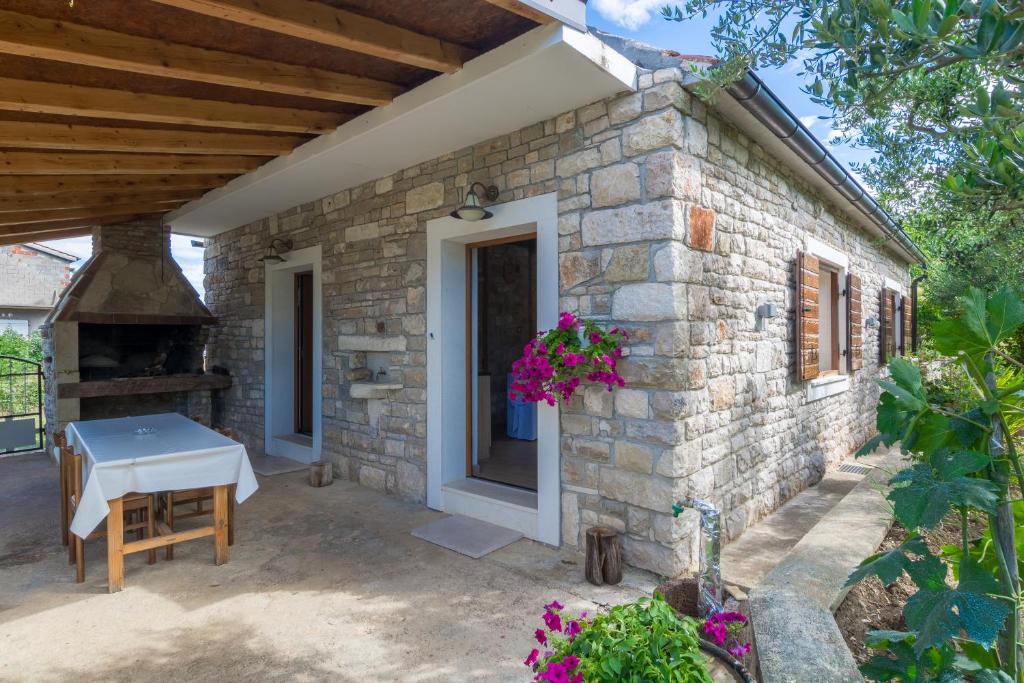 ein Backsteinhaus mit einem Tisch und einem Kamin in der Unterkunft Casa Mala in Zadar