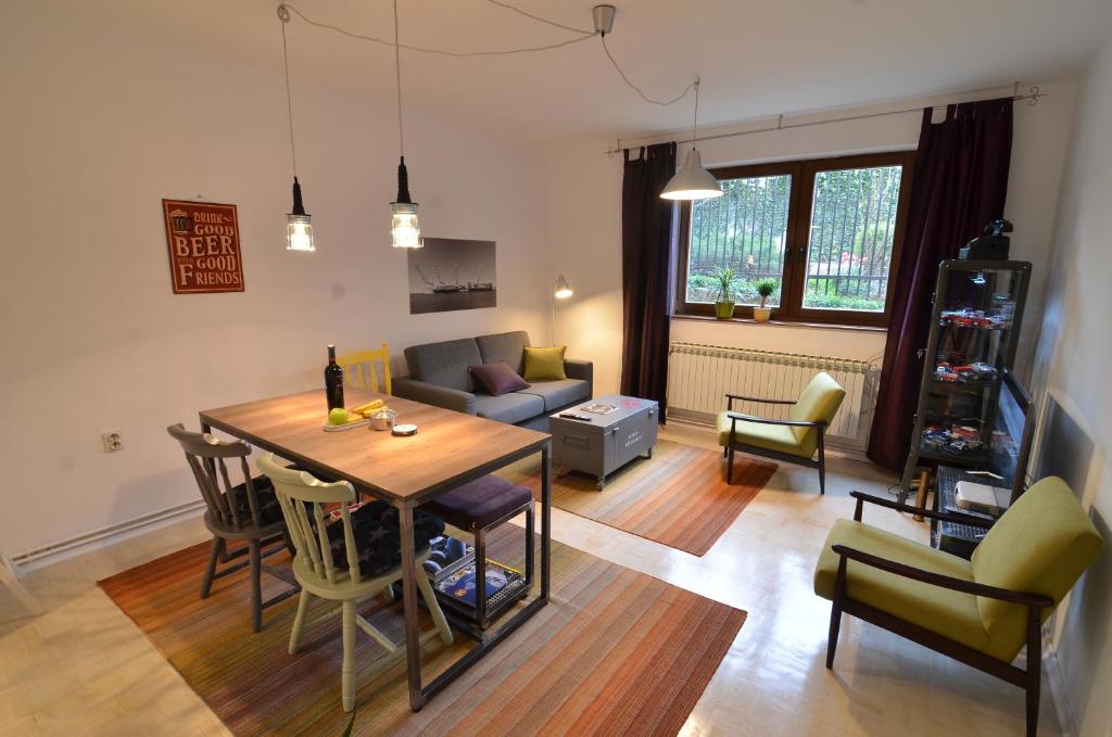 ein Wohnzimmer mit einem Tisch, Stühlen und einem Sofa in der Unterkunft Embassy of Industry + free parking in Sarajevo
