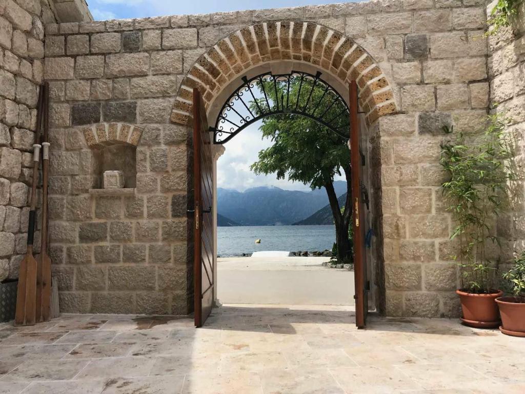 uma entrada para um edifício de pedra com uma porta aberta em Stone house 264 em Kotor