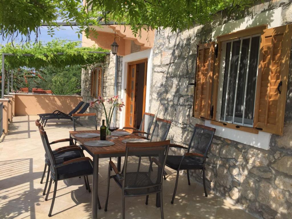 a wooden table and chairs on a patio at Apartman Toni in Lukoran