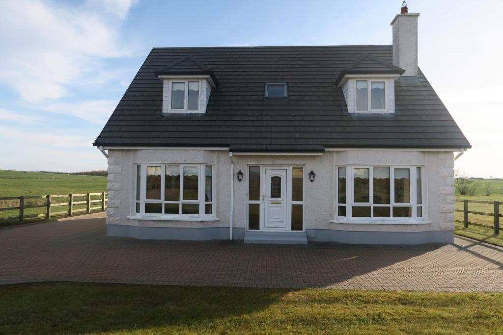 una casa blanca con techo negro en THISTLEDOWN - Ballina - Crossmolina - County Mayo - Sleeps 8 - Sister property to Inglewood, en Ballina