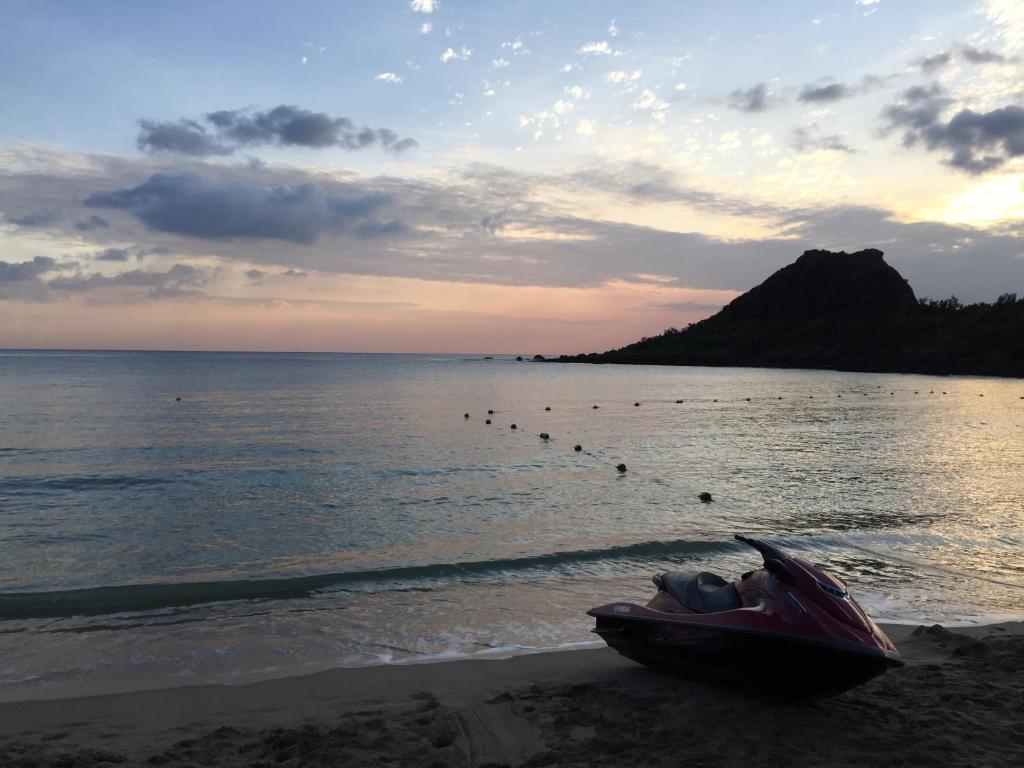 a red boat sitting on the shore of a beach at Kenting Peninsula Inn in Kenting