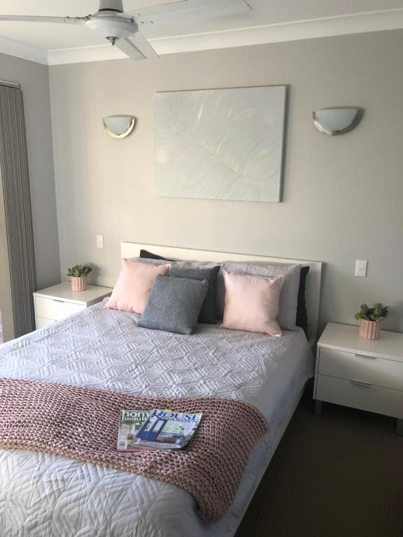 a bedroom with a bed with pink and grey pillows at Dampier House Mullaloo-Perth in Perth