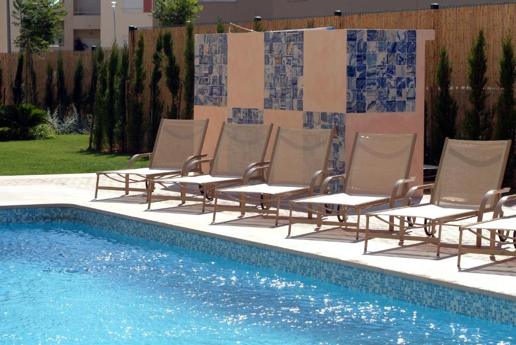 a group of chairs sitting next to a swimming pool at Hotel Real Oeiras in Oeiras