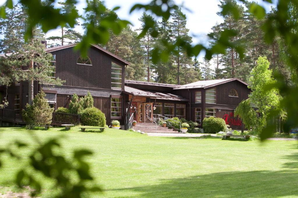 ein Haus mit grünem Rasen davor in der Unterkunft Mullsjö Hotell & Konferens in Mullsjö