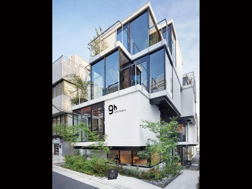 a tall white building with glass windows on a street at 9h nine hours Akasaka in Tokyo