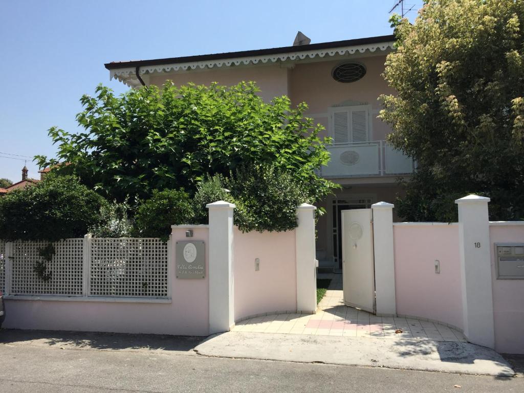 einen weißen Zaun vor einem Haus in der Unterkunft Villa Amelia Rooms in Marina di Pietrasanta