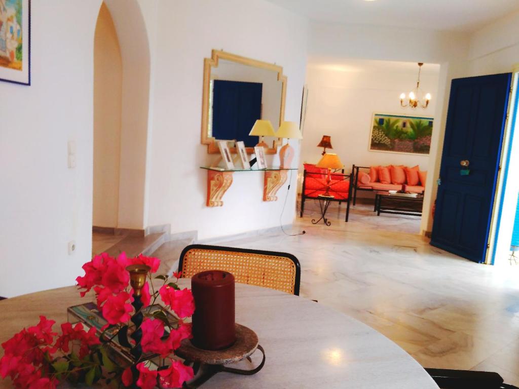 a living room with a table with red flowers on it at Villa Kavalli Paros in Dhragoulás