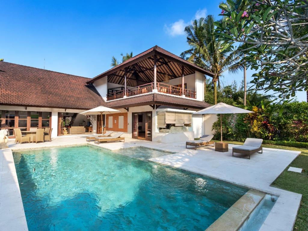 a villa with a swimming pool and a house at Villa Candi Kecil Empat in Ubud