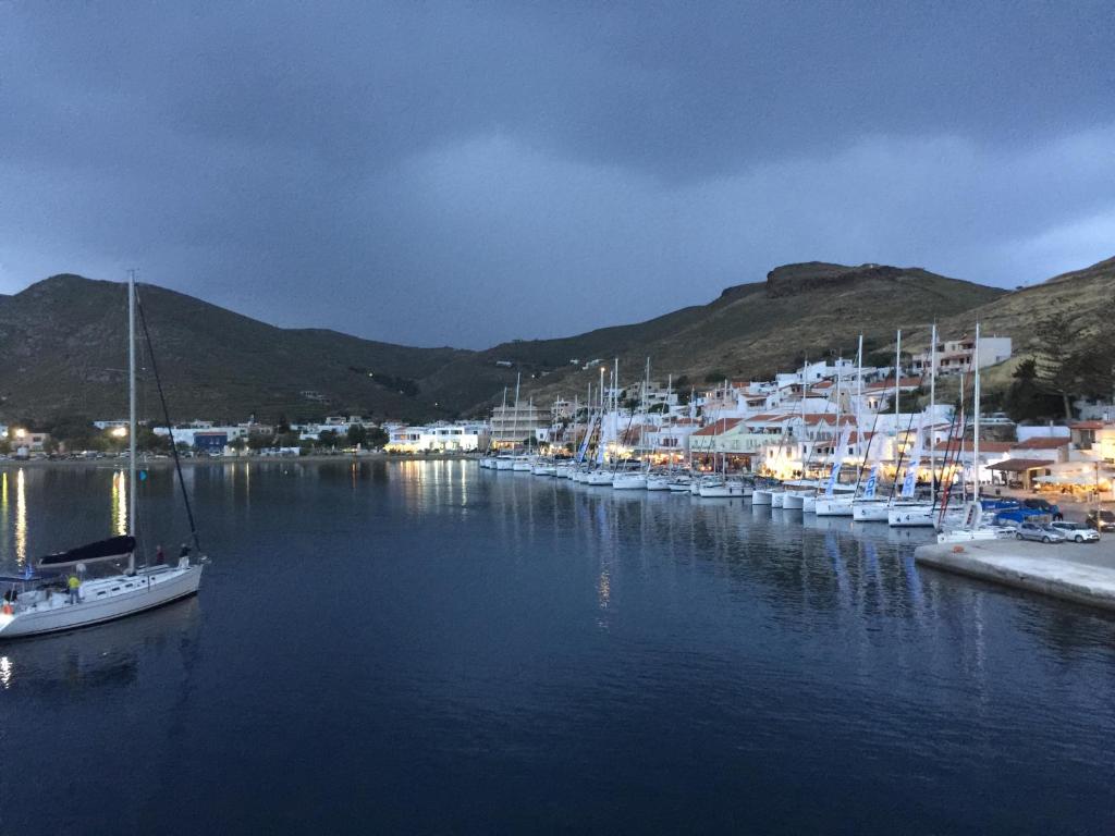 een groep boten aangemeerd in een haven 's nachts bij Hotel Karthea in Korissia