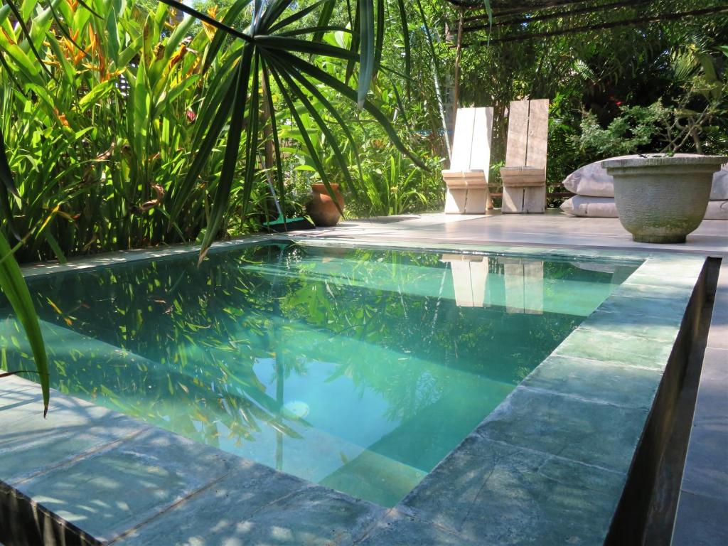 a swimming pool in a yard with plants at Breathe Villa Meno in Gili Meno