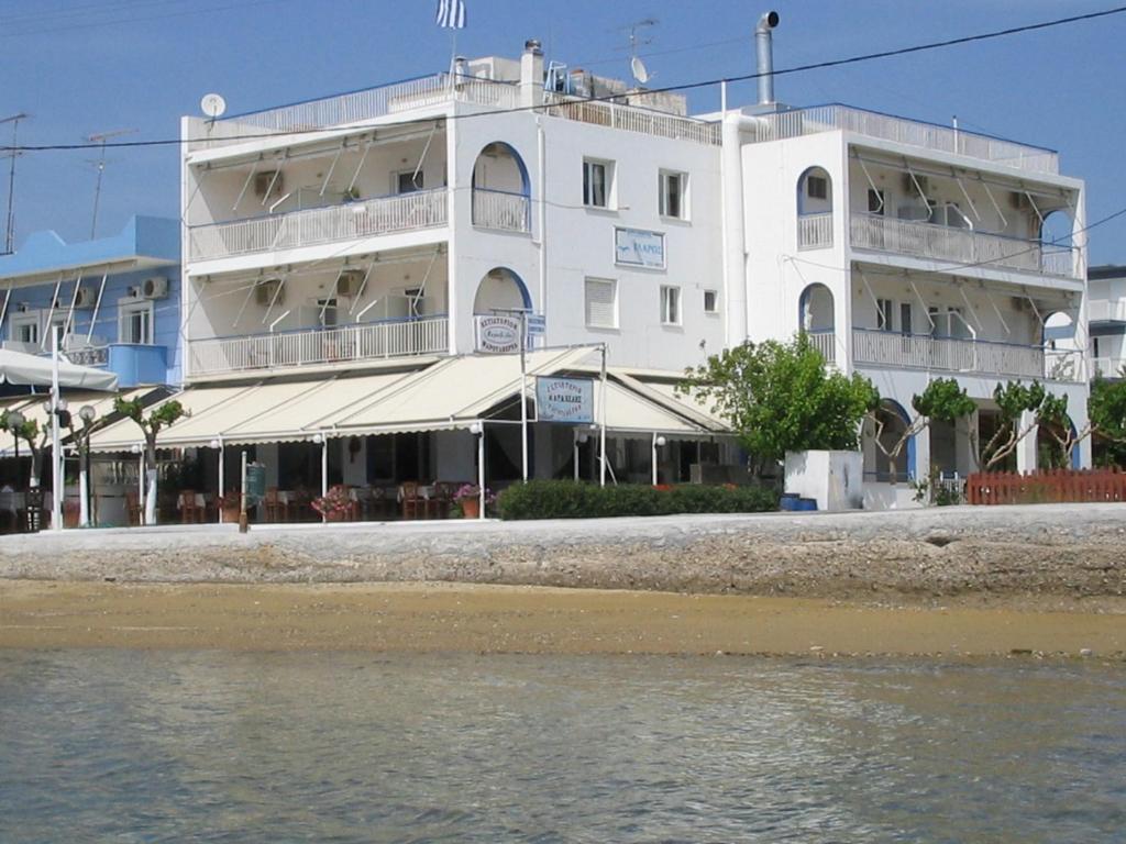 - un bâtiment blanc sur la plage au bord de l'eau dans l'établissement Glaros Studios, à Loutra Edipsou
