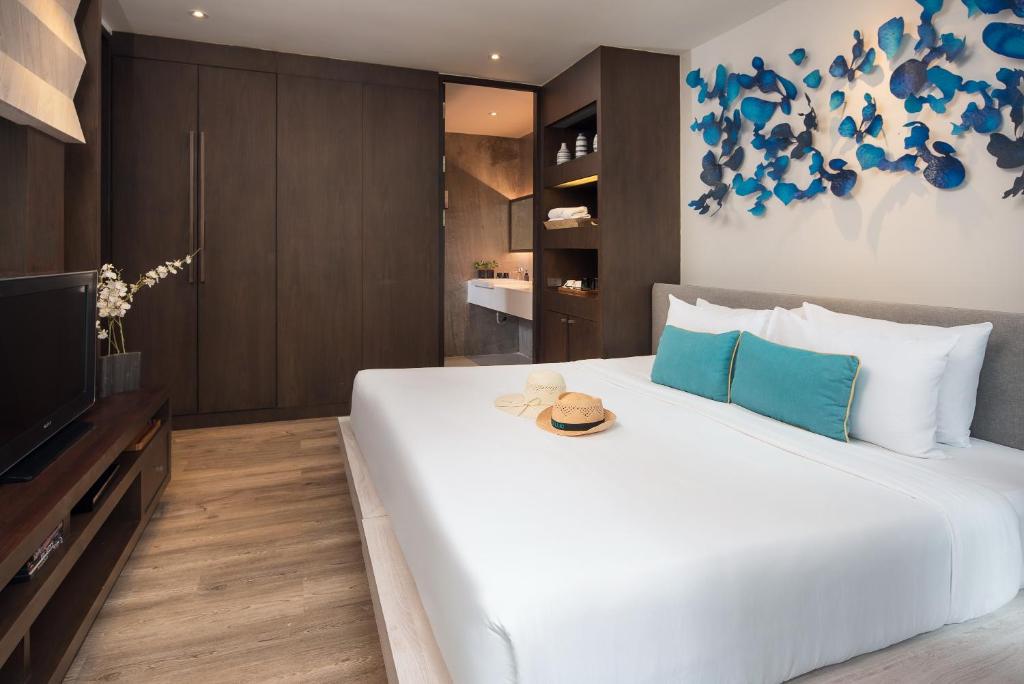 a bedroom with a large white bed and a television at Idyllic Concept Resort in Ko Lipe