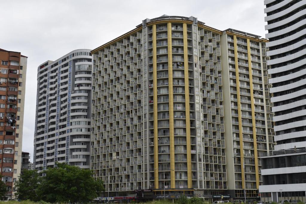 a large apartment building in a city with tall buildings at Hotel Orbi Plaza in Batumi