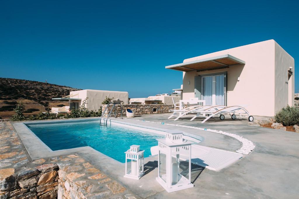 uma villa com uma piscina e uma casa em Schinoza Luxury Suites em Skhoinoussa