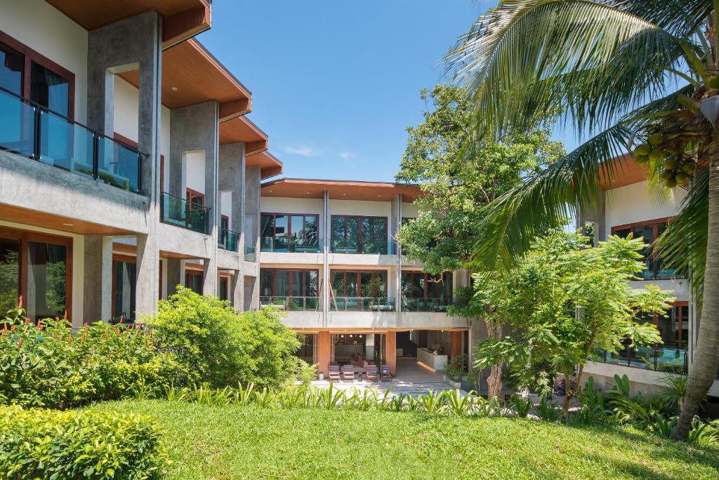 an external view of a building with a palm tree at Idyllic Concept Resort in Ko Lipe