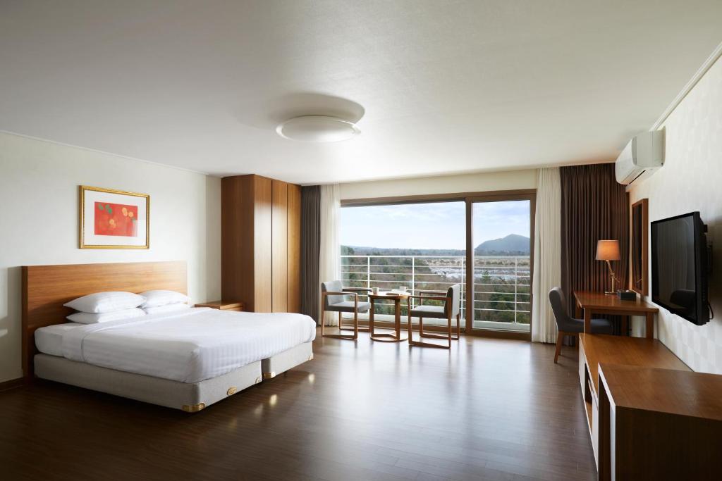 Postel nebo postele na pokoji v ubytování Jeju Aerospace Hotel