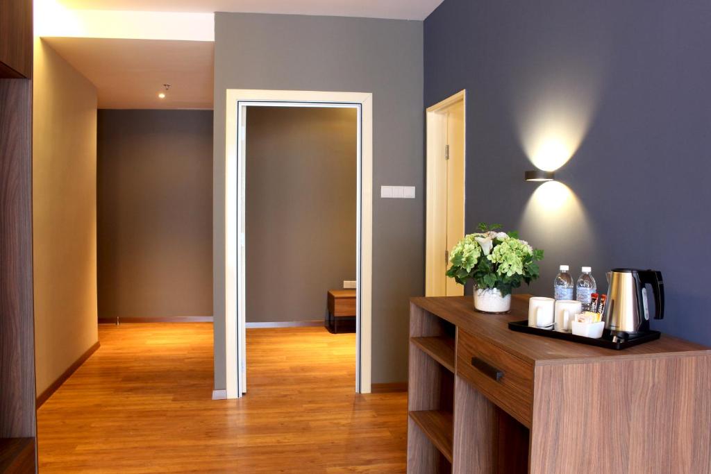 An entry hall with a console holding drinks, a kettle and hotel supplies.