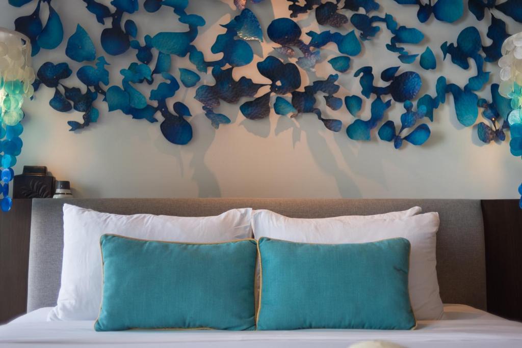 a bedroom with a bed with blue and white pillows at Idyllic Concept Resort in Ko Lipe