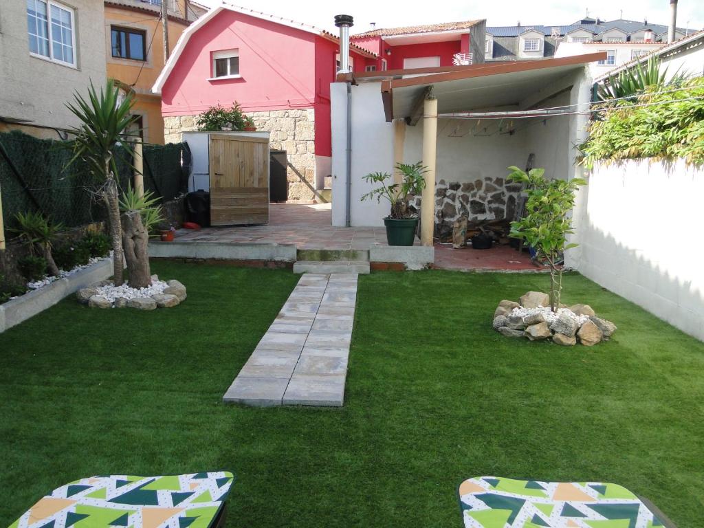 a small backyard with a yard with green grass at Casa de Joaquina in O Grove