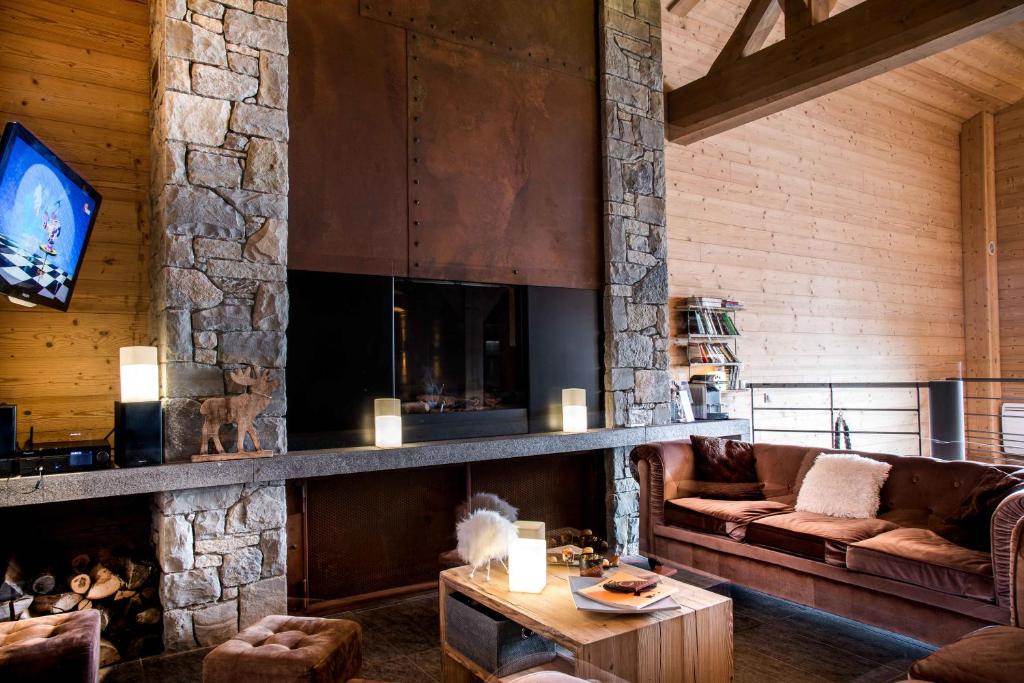 a living room with a couch and a fireplace at Résidence - Les Grandes Alpes in La Clusaz