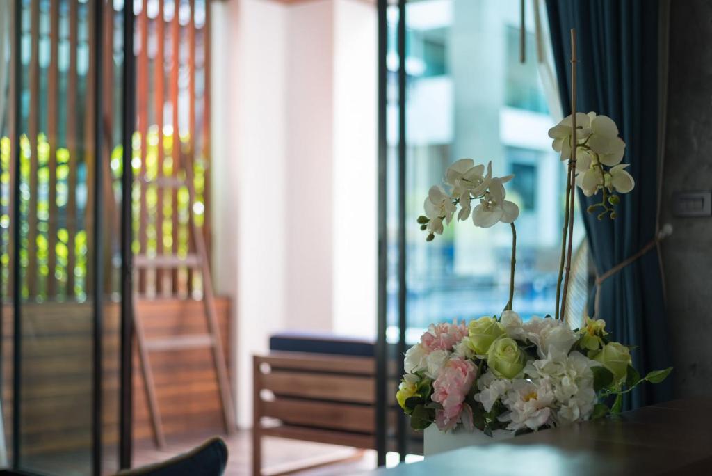 a vase filled with flowers sitting on a table at Idyllic Concept Resort in Ko Lipe