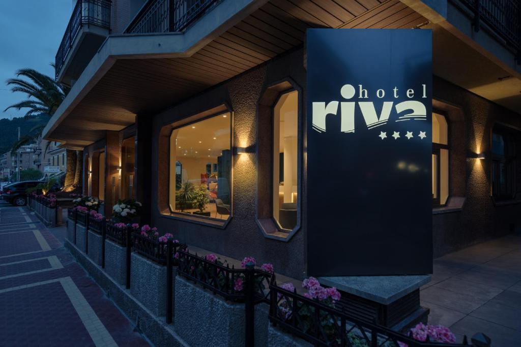 een winkel met een bord aan de zijkant van een gebouw bij Hotel Riva in Alassio