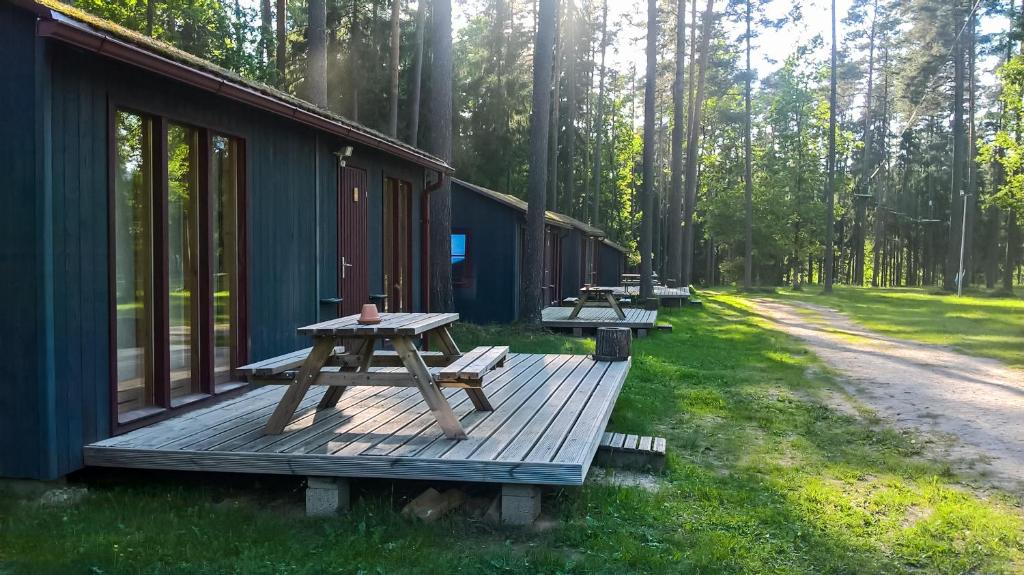 a picnic table on a deck next to a cabin at Kempings Ozolkalns in Cēsis