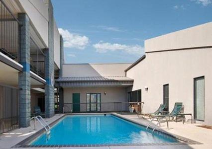 a swimming pool in front of a building at Executive Inn and Suites in Enterprise