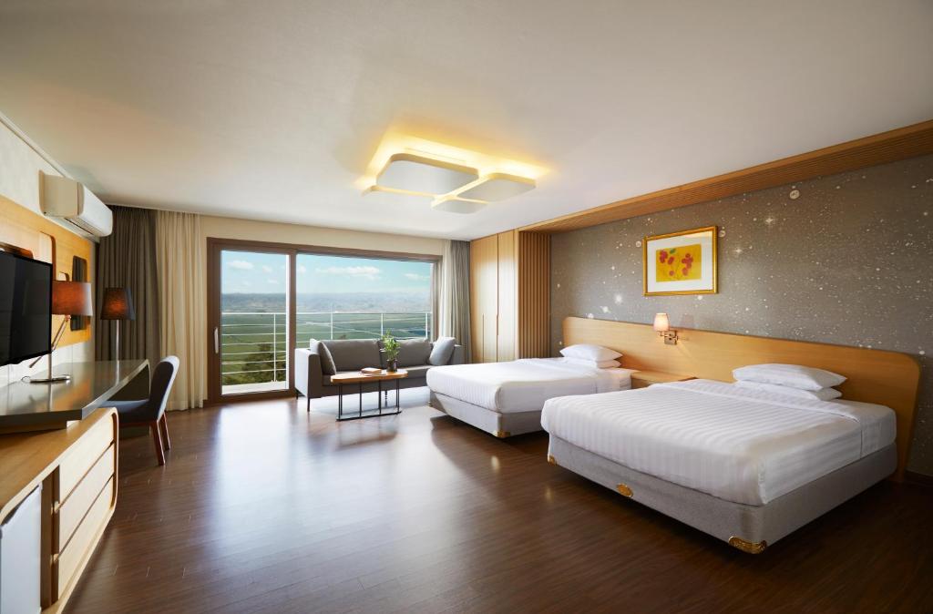 Postel nebo postele na pokoji v ubytování Jeju Aerospace Hotel