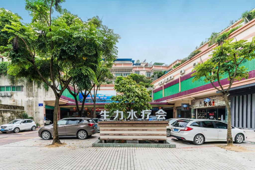 eine Holzbank in der Mitte einer Straße mit Autos in der Unterkunft Shengli Hydrotherapy Vacation Hotel in Jiangmen