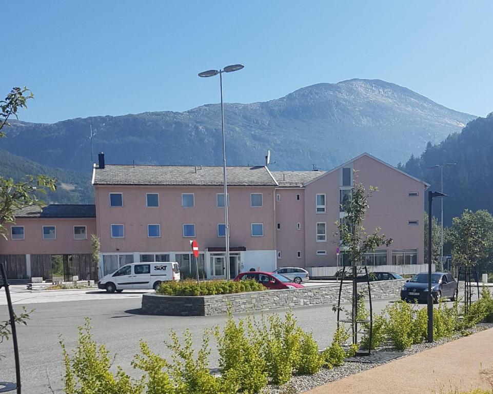 Glomfjord的住宿－Glomfjord Hotel，停车场内停放汽车的大型建筑