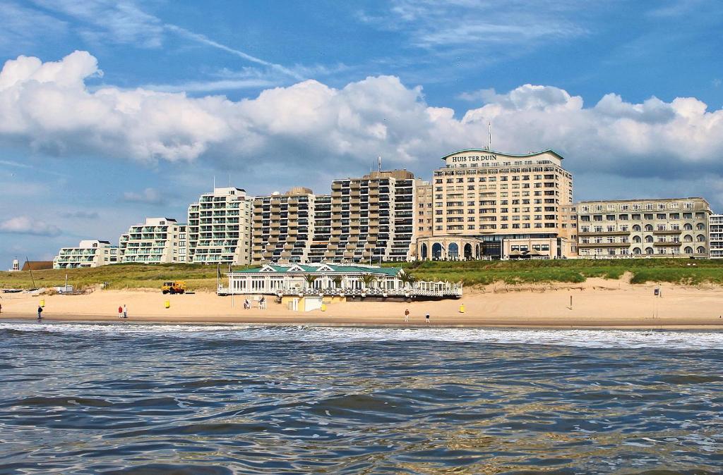 einen Strand vor einer Stadt mit hohen Gebäuden in der Unterkunft Grand Hotel Huis ter Duin in Noordwijk aan Zee