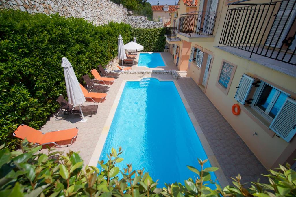 an overhead view of a swimming pool with chairs and umbrellas at Gabriel Houses in Agia Effimia