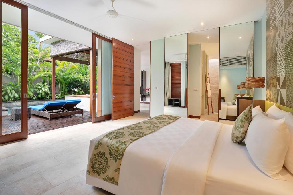 een slaapkamer met een groot bed en een patio bij The Elysian Boutique Villa Hotel in Seminyak